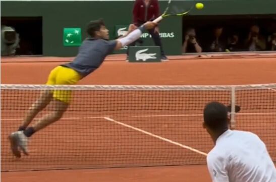 Carlos Alcaraz se estira para llegar a una bola en la red en Roland Garros