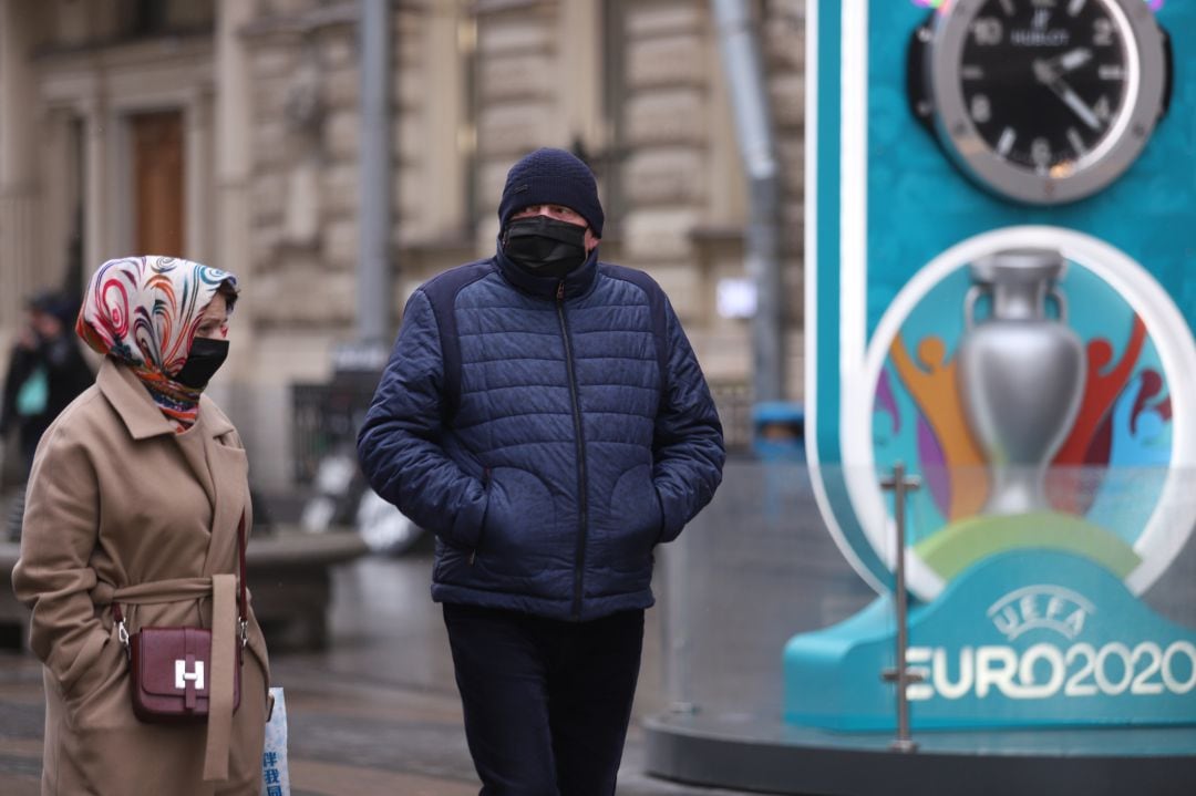 Dos personas pasan delante de un cartel de la Eurocopa 2020.