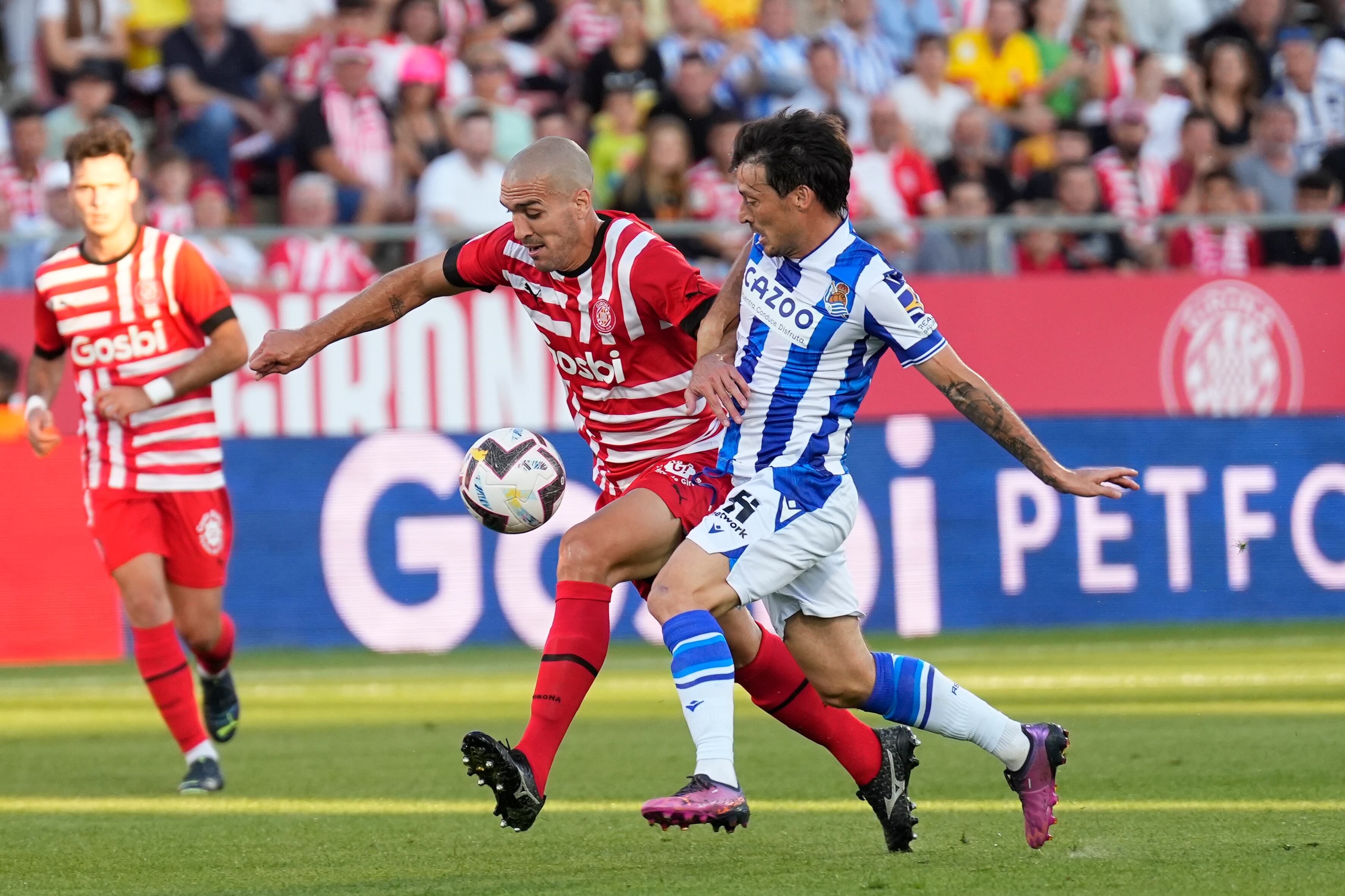 Girona, 02/10/2022. El centrocampista del Girona FC Oriol Romeu, y el centrocampista de la Real Sociedad David Silva, durante el partido de la jornada 7 de LaLiga Santander, este domingo en el estadio municipal de Montilivi.- EFE/David Borrat.
