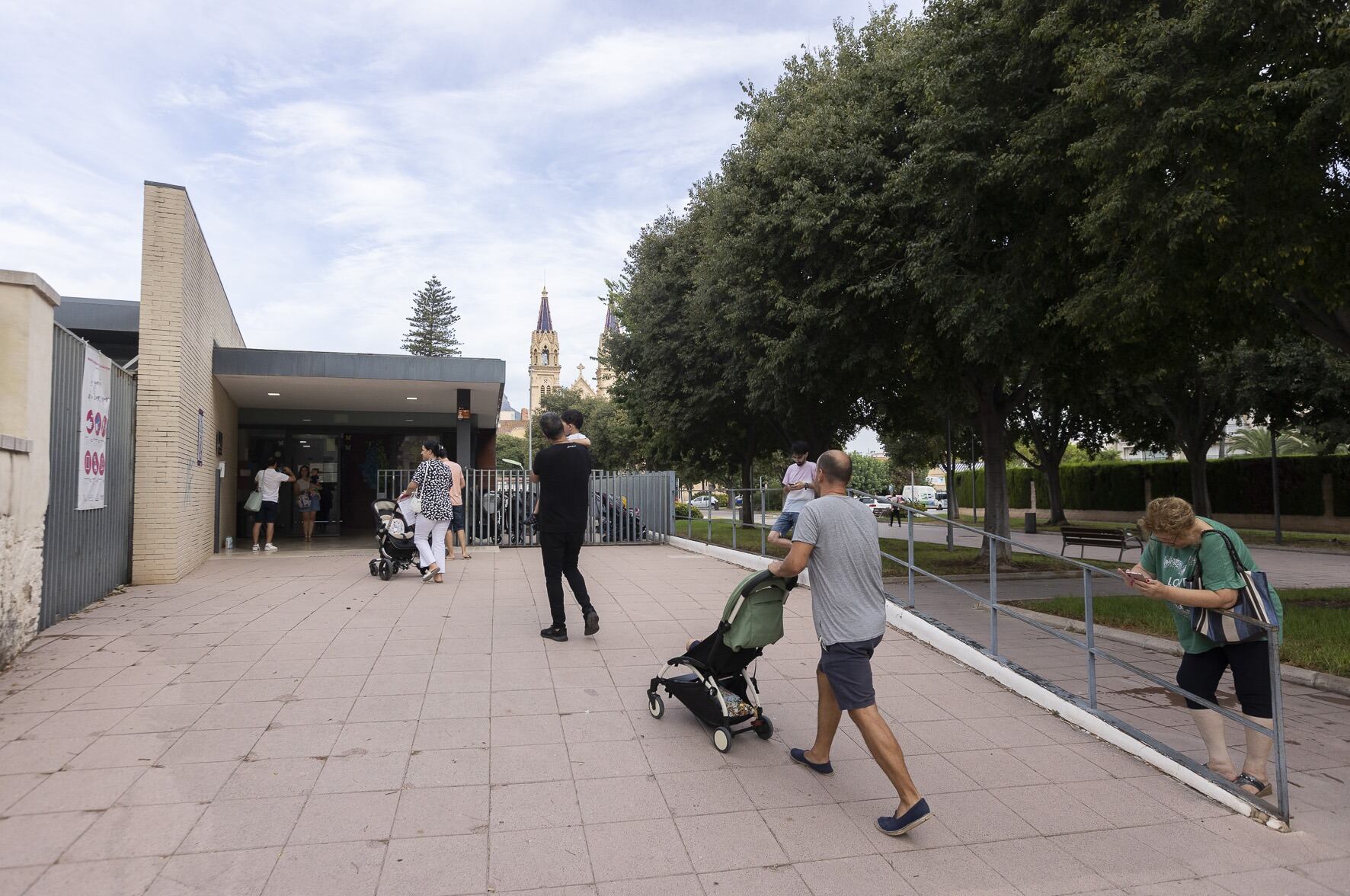 Padres y madres dejando a sus hijos en una escoleta municipal.