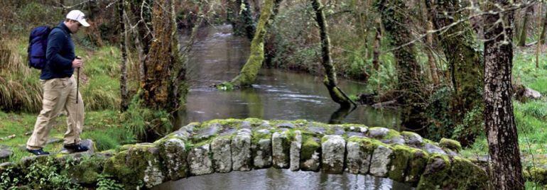 Un peregrino cruza un puente a su paso por Pontevedra