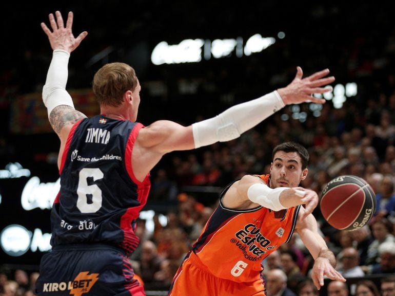 El alero del Valencia Basket Alberto Abalde (d) centra el balón frente al letón Janis Timma, del Baskonia, durante el partido de Liga ACB que se juega esta noche en la Fuente de San Luis, en Valencia.