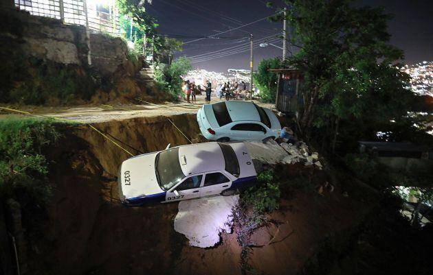 Dos coches a punto de caer a un barranco por el suelo reblandecido, debido al sismo de 7.1, en el balneario de Acapulco.