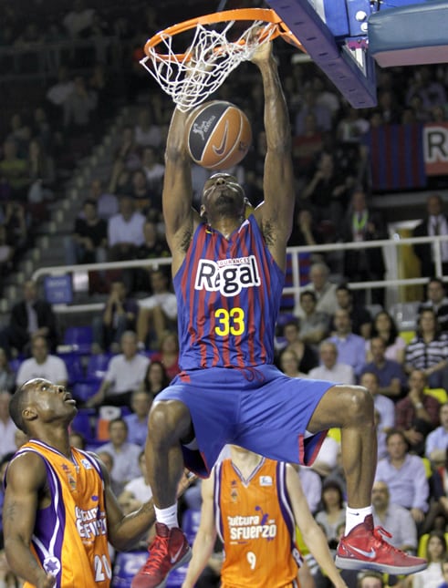 El alero estadounidense del Regal Barcelona, Pete Mickeal, machaca la canasta ante el francés Florent Pietrus, del Valencia Basquet, durante el primer partido de las semifinales de la Liga ACB disputado esta noche en el Palau Blaugrana, en Barcelona