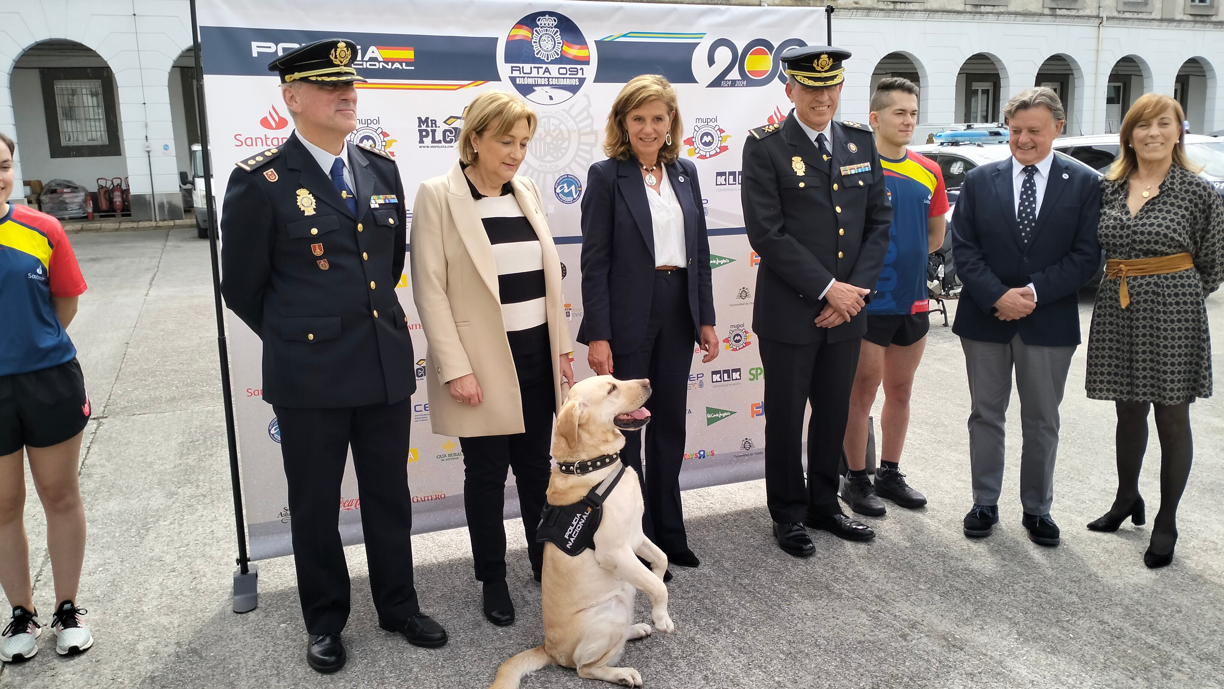 El Jefe Superior de Policía de Asturias, la Delegada del Gobierno, el concejal de Seguridad Ciudadana de Oviedo y otras autoridades posan en el photocall de la carrera junto a la perra &quot;Seven&quot;