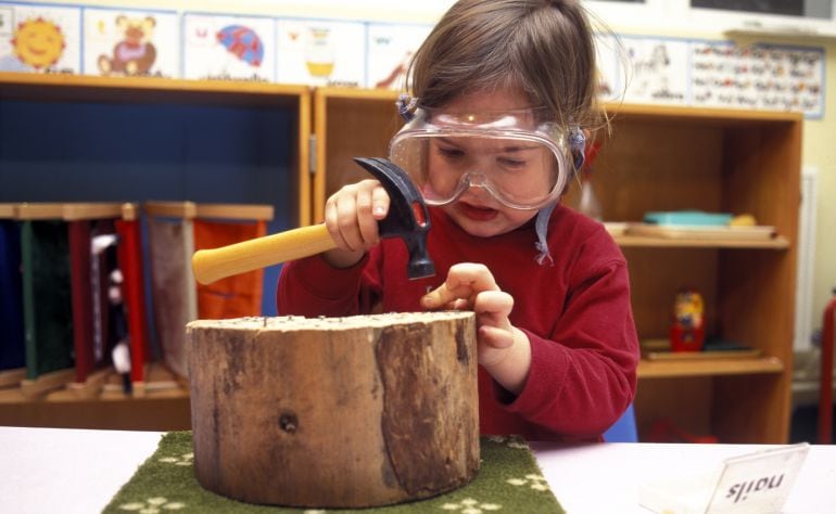 Una niña trabaja con la madera en una escuela Montessori.