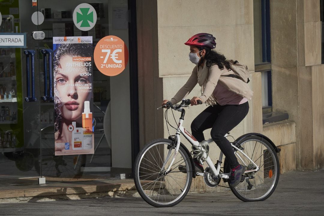 Una mujer con mascarilla y bici en una céntrica calle de Pamplona, Navarra (España) a 17 de julio de 2020