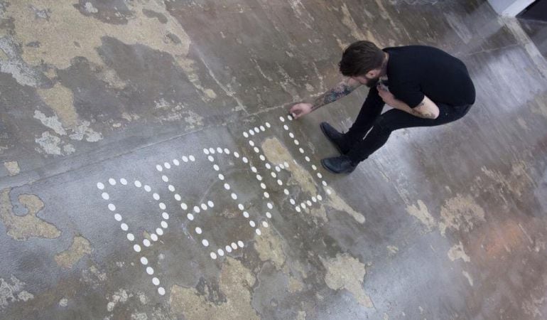 El artista Abel Azcona durante la colocación de la performance.