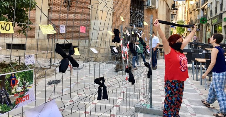 Una mujer muestra su rechazo a las obras con tapándose la boca con un lazo negro.