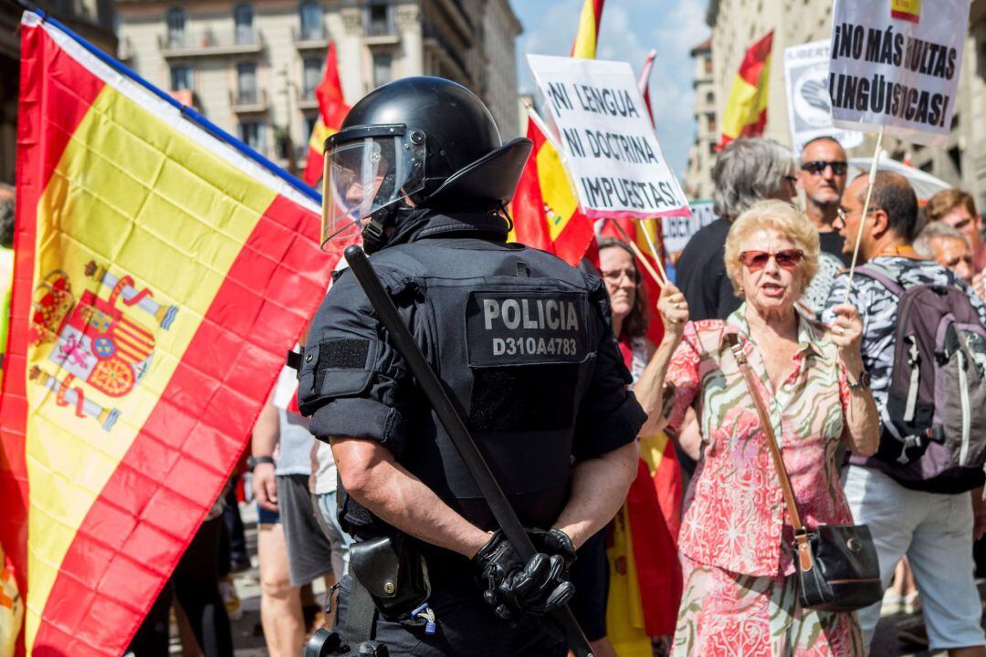 Agentes de los Mossos d&#039;Esquadra impiden el paso a un grupo de personas hacia la plaza de Sant Jaume para asistir a la concentración convocada por la asociación Hablamos Español