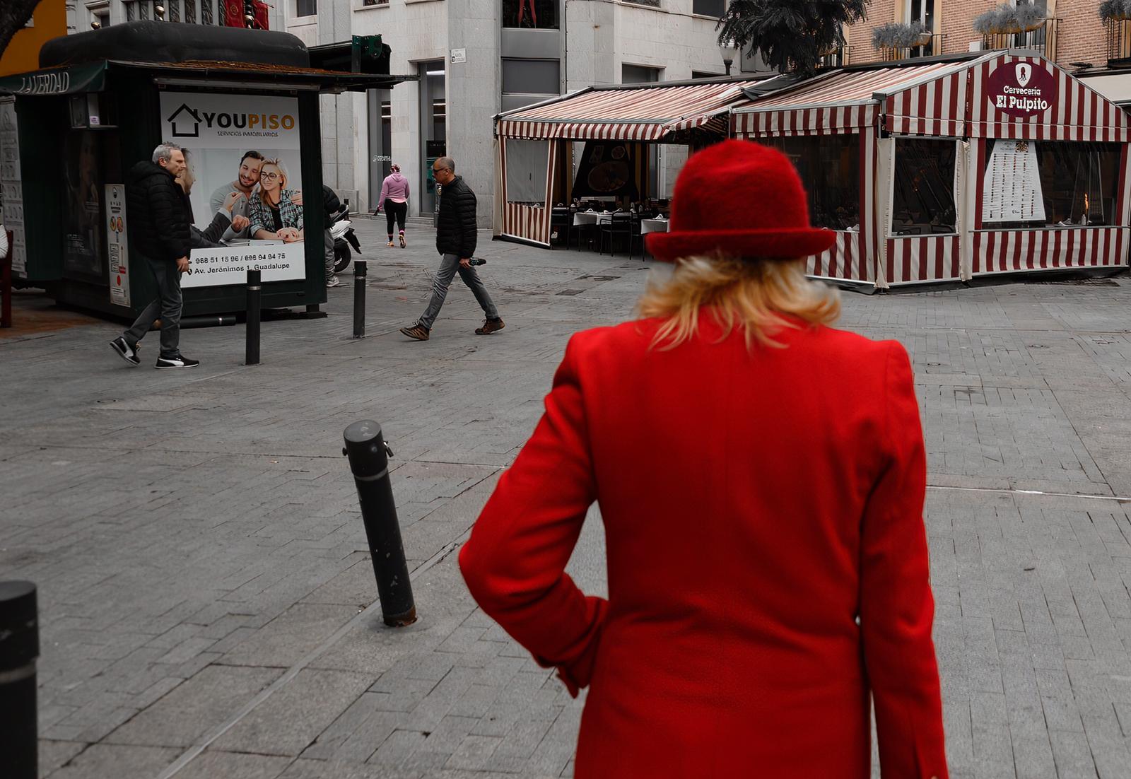 Mujer de rojo pasea por la plaza de las Flores de Murcia. Pepe Jara.