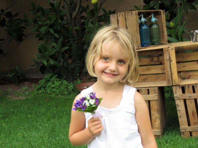 Una niña recogiendo un ramo de flores