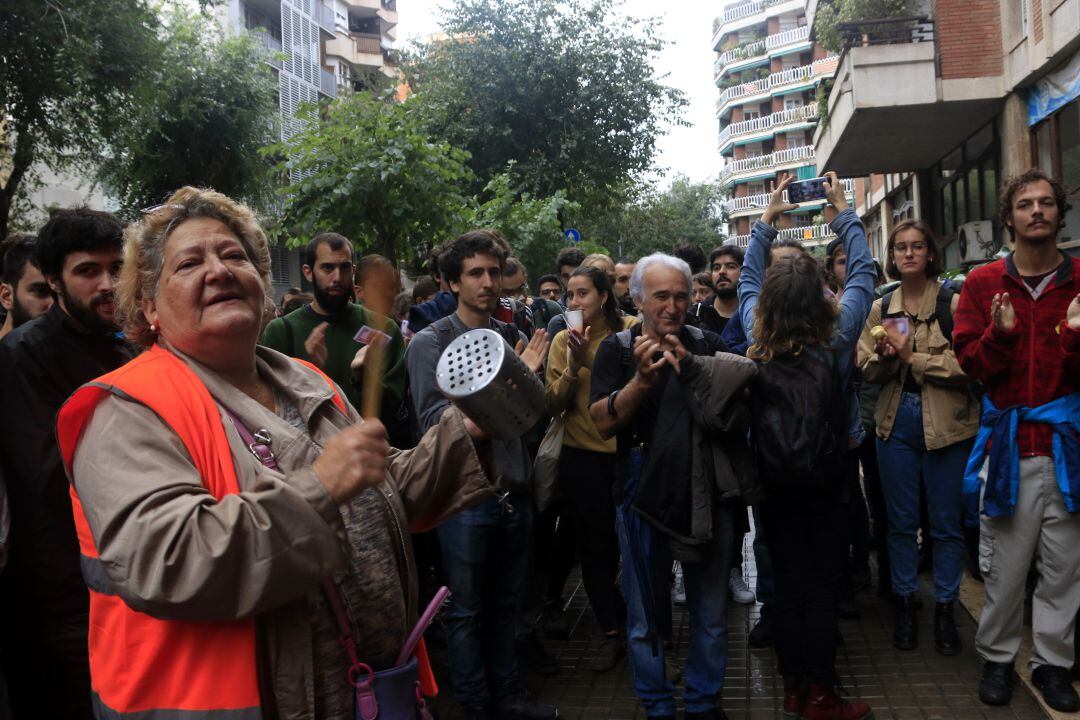 Una dona fa sonar estris culinaris en la concentració davant d'un edifici de Travessera de Gràcia per evitar el desnonament de la família del Juan i la Lívia a l'octubre de 2019