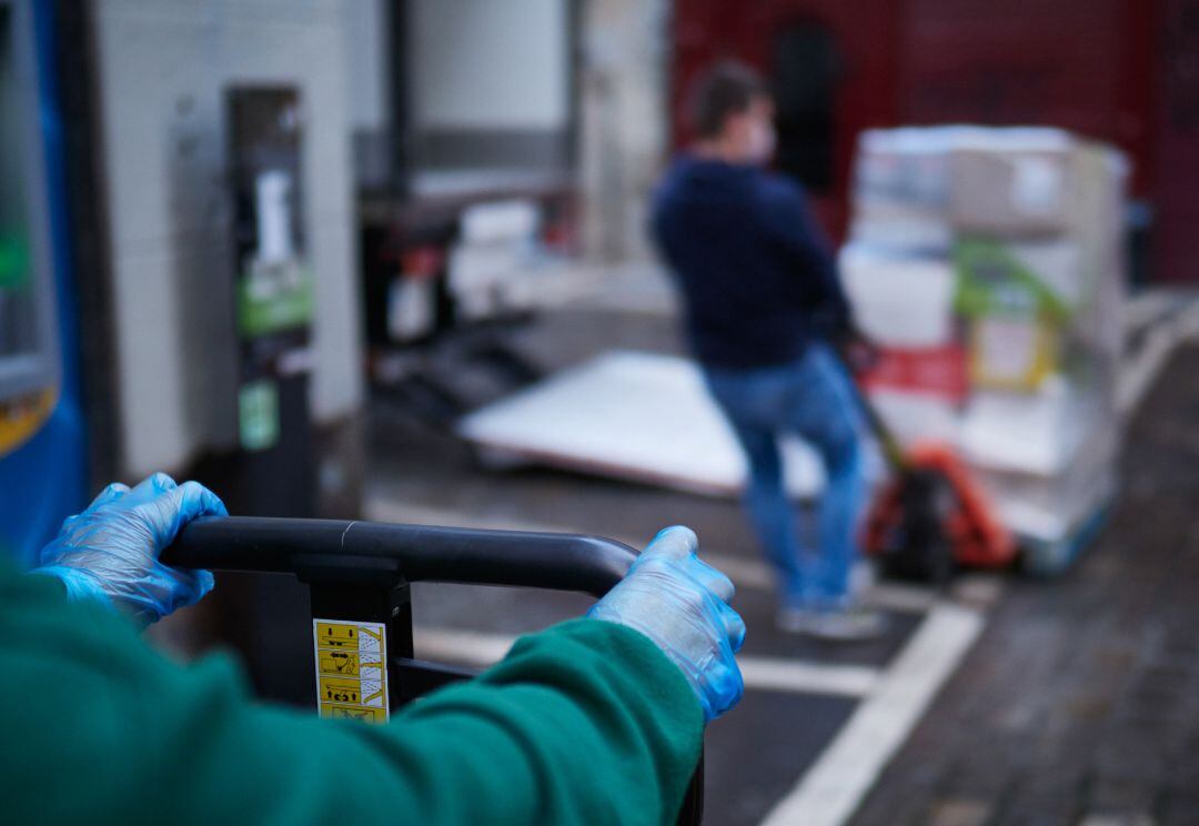 Un trabajador de reparto mueve productos de su camión aparcado en las calles de Pamplona.