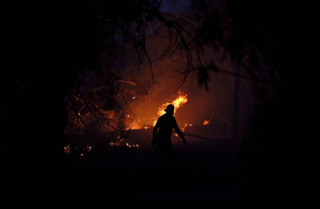 Un vecino ante el incendio declarado en Varympompi, al norte de Atenas (Grecia), el 3 de agosto de 2021.