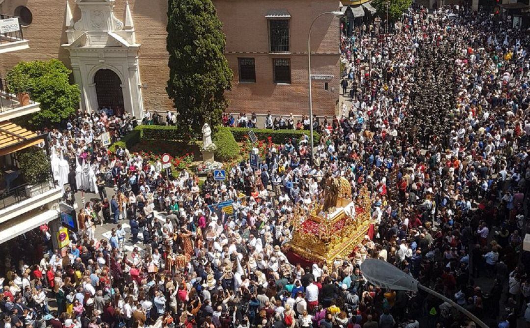 El paso del Señor Resucitado, arropado por centenares de cofrades, a la altura del monumento a Santa Ángela de la Cruz