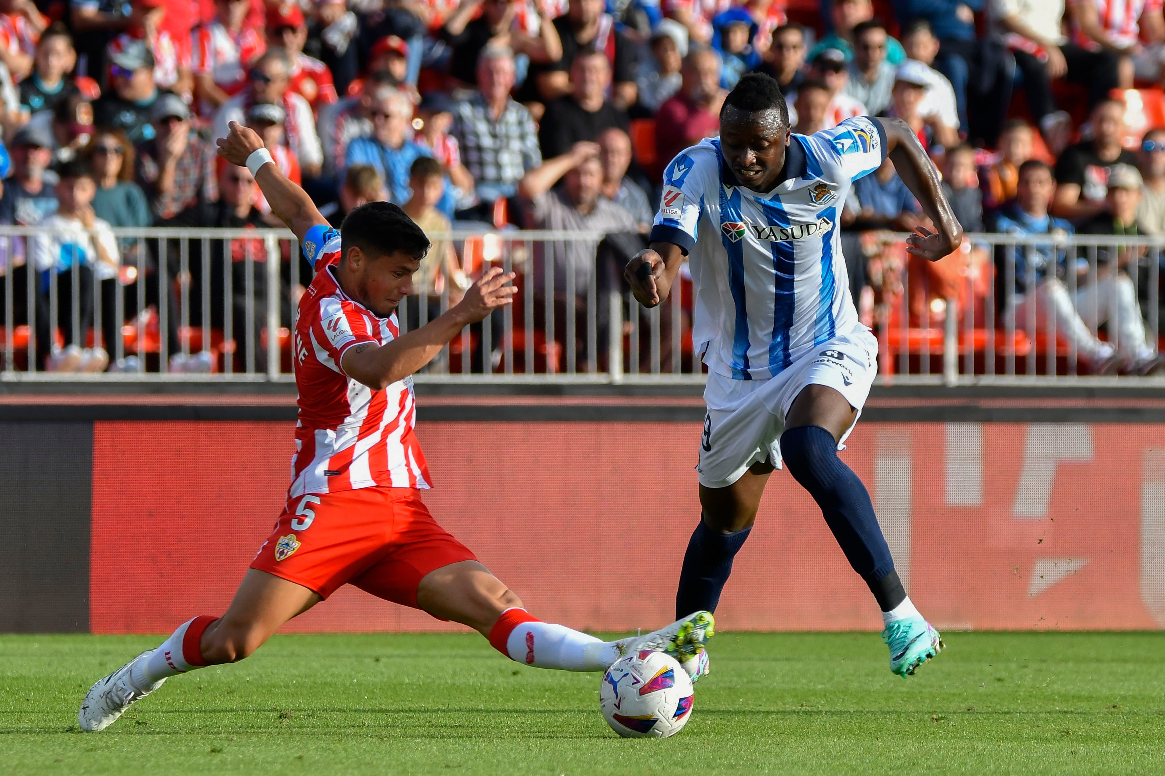 ALMERÍA 11/11/2023.- El delantero de la Real Sociedad Sadiq Umar (d) disputa un balón con el centrocampista de la UD Almería Lucas Robertone durante el partido disputado este sábado en el Power Horse Stadium de Almería. EFE / Carlos Barba