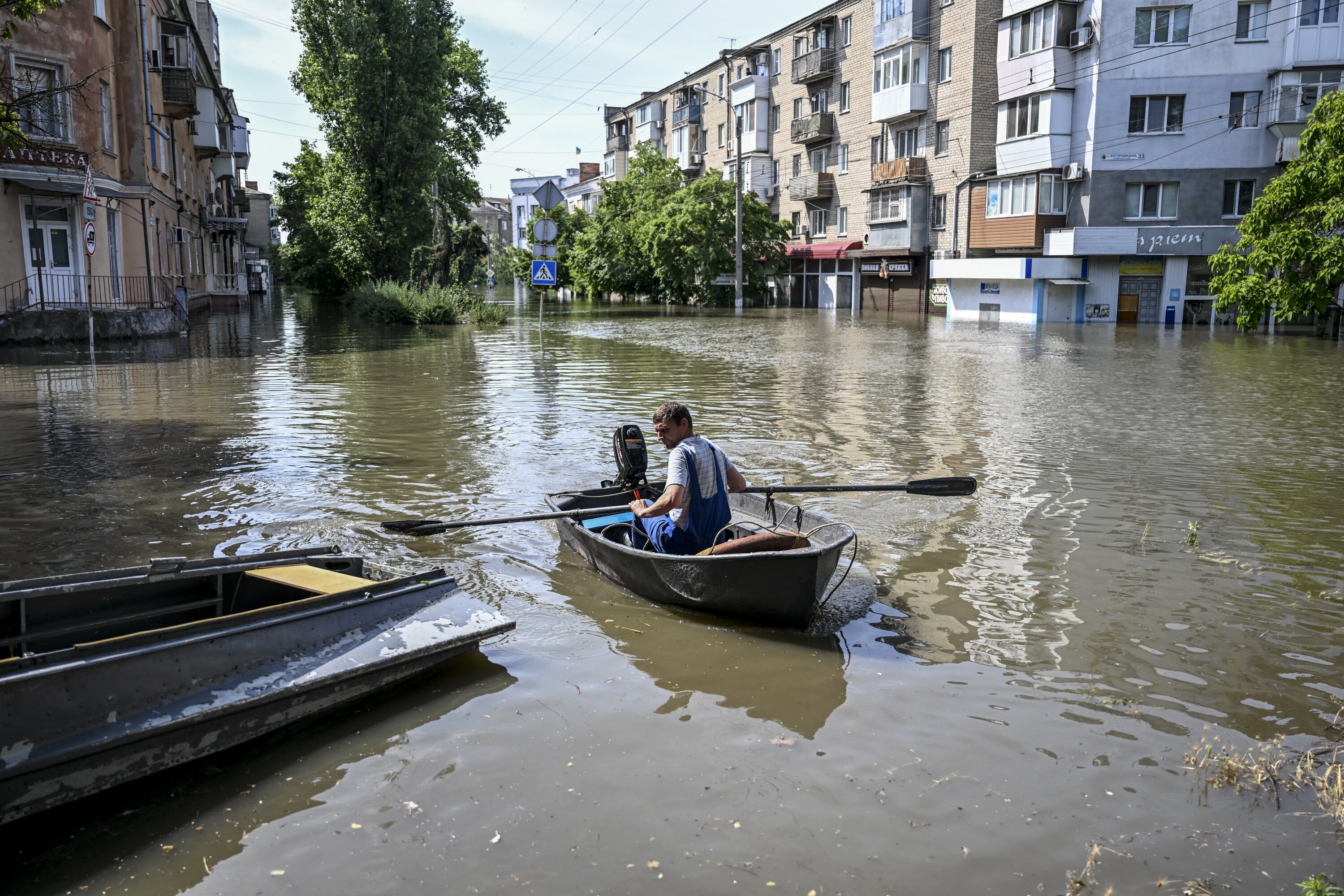 Ciudadanos de la localidad de Jersón utilizan botes para moverse por la ciudad después del derrumbe de la presa de Kajovka