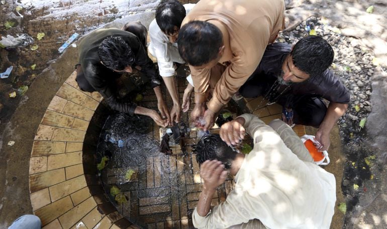 Varios hombres se refrescan durante un caluroso día en Karachi (Pakistán).