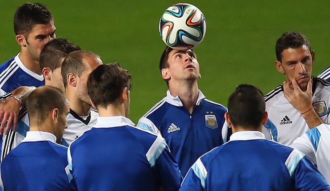 El astro argentino controla un balón con la cabeza en plena charla de los jugadores de la albiceleste.