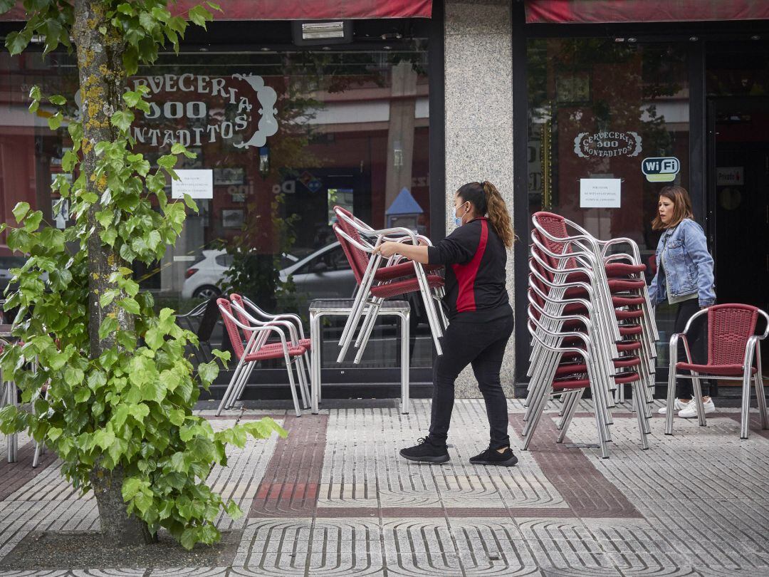 Una camarera prepara la terraza de una cervecería
