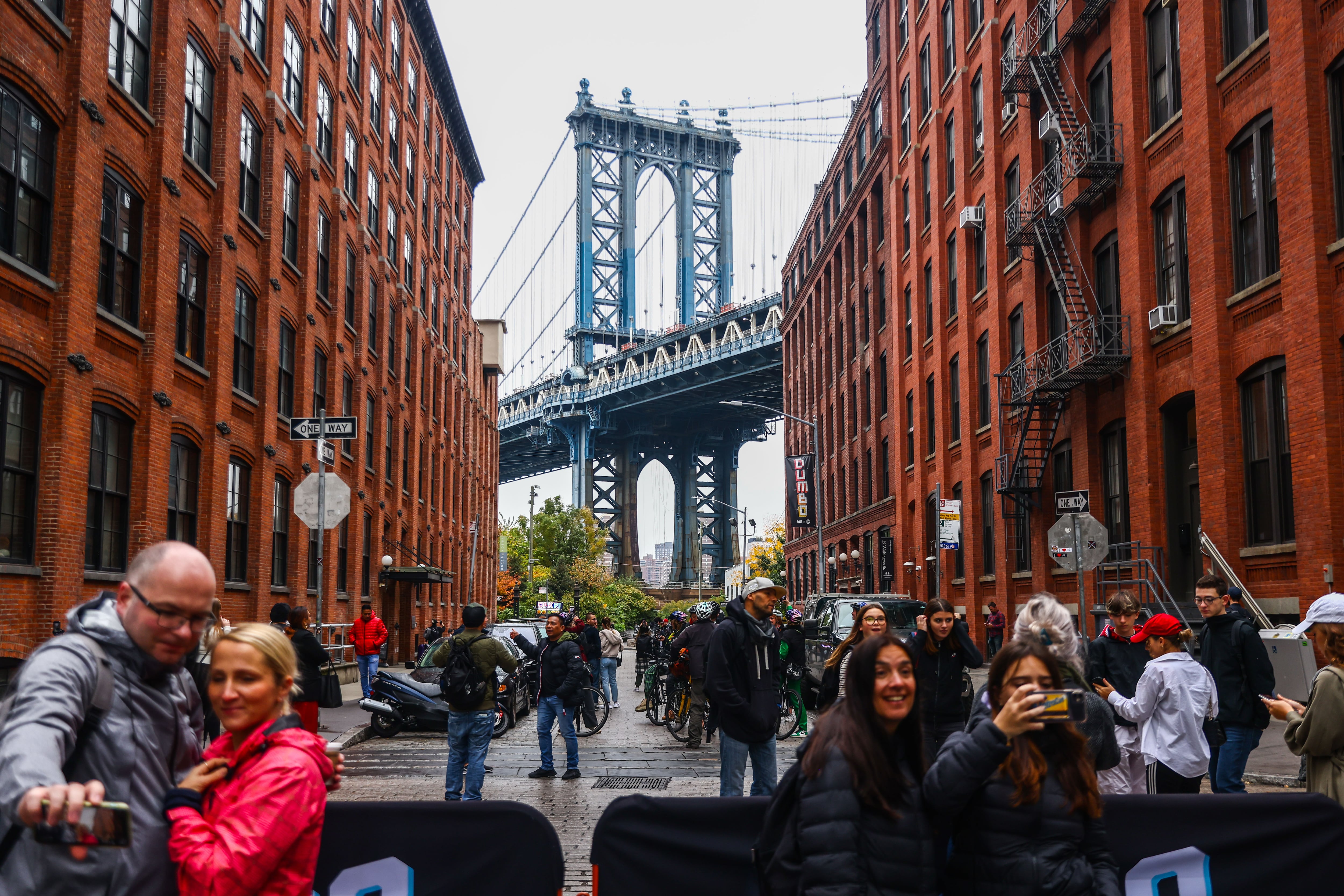 Varios turistas se fotografían frente al puente de Manhattan, en Nueva York.