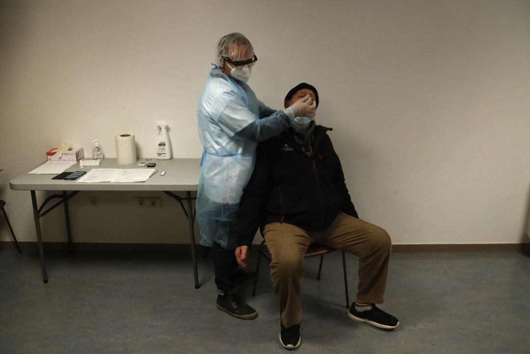 A medical worker takes nasal swab samples at a test station for Covid-19