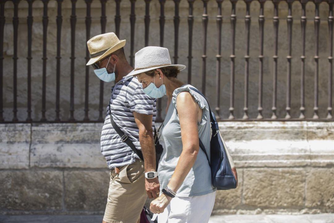 Una pareja pasea con mascarilla