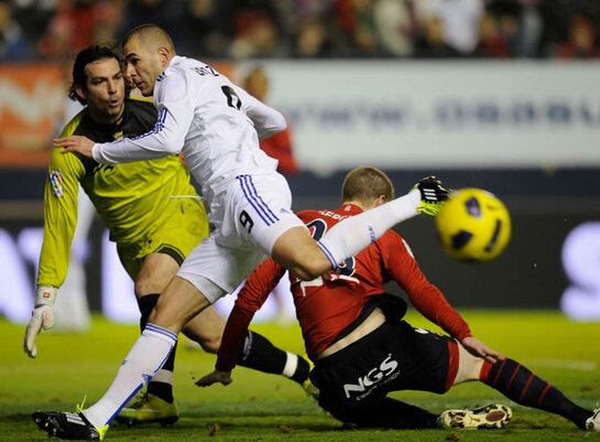 Benzema lucha por el balón ante el portero del Osasuna durante el partido de la 21ª jornada de la Liga BBVA