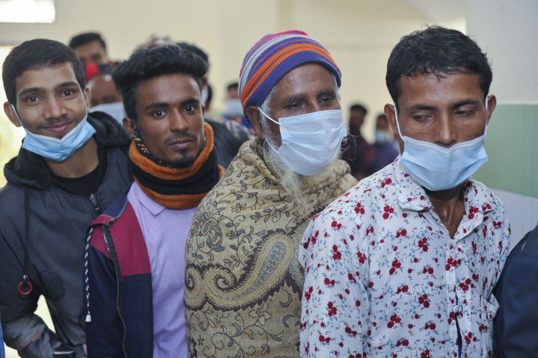 Varias personas hacen cola en un centro de vacunación contra el COVID en un hospital de Bangladesh.