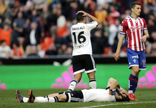 GRA165. VALENCIA, 31/01/2016.- Los jugadores del Valencia CF, Negredo (en el suelo) y Bakkali, se lamentan de una ocasión fallida ente el Sporting de Gijón durante el partido de la vigésima segunda jornada de liga en Primera División que se disputa esta t