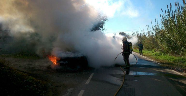 Imatge dels bombers apagant el vehicle incendiat, al Camí de Granyena