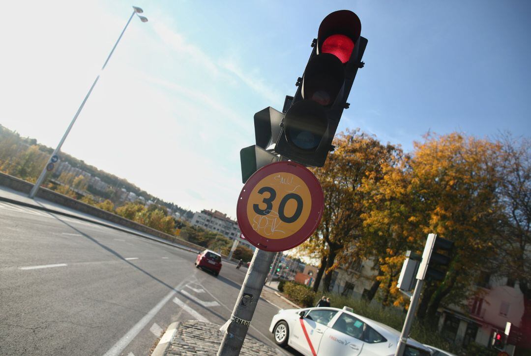 Varios coches circulan al lado de una señal de tráfico el mismo día en que han aprobado la reducción de la velocidad 