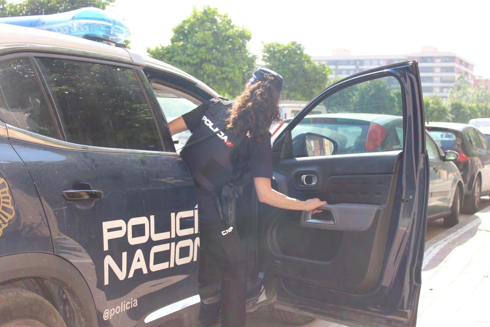 Imagen de archivo de una agente de la Policía Nacional entrando en un coche patrulla