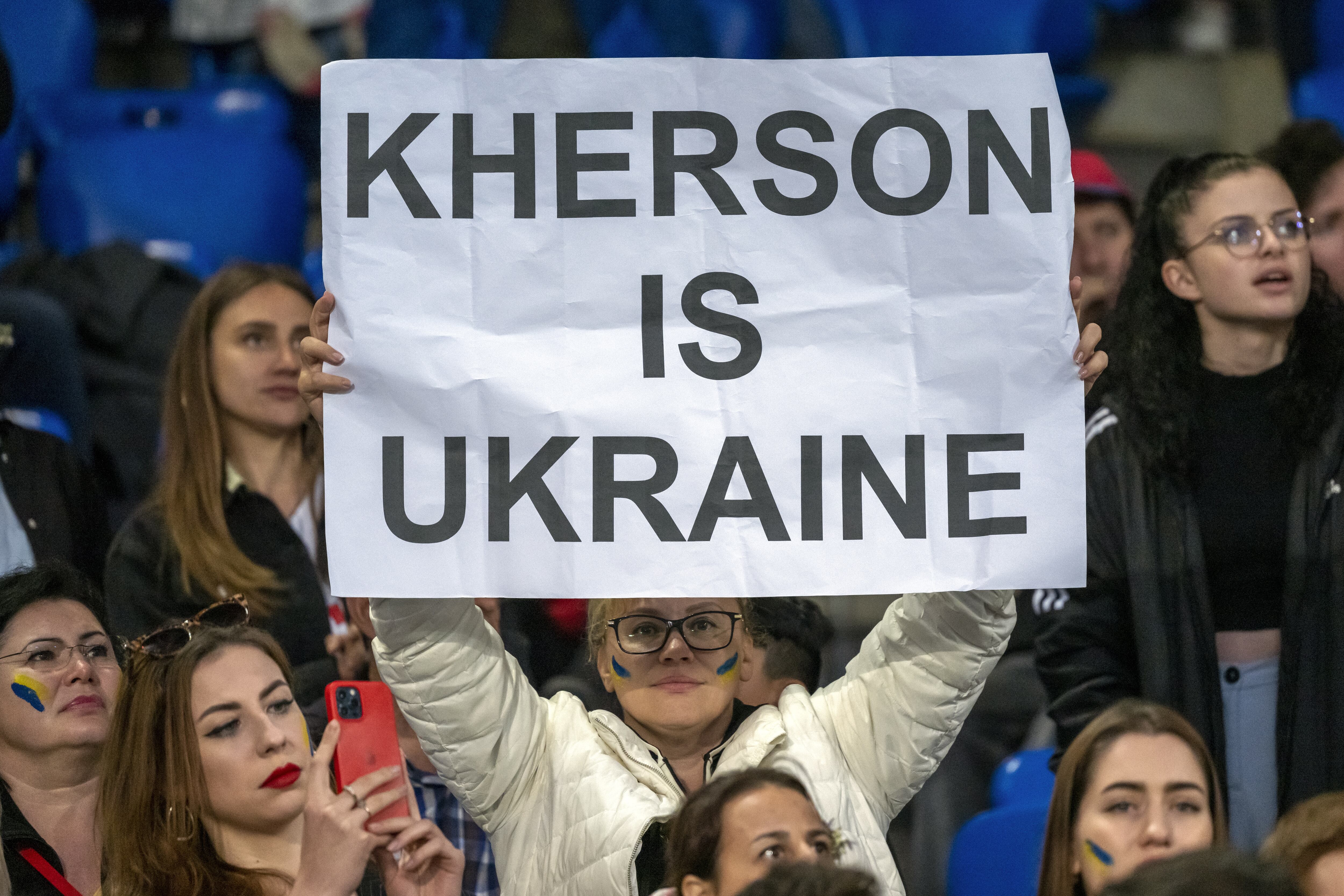 Una mujer sostiene una pancarta con el lema &quot;Kherson es Ucrania&quot; durante un partido de fútbol &quot;por la paz&quot; disputado este miércoles en Suiza entre el FC Basel 1893 y el FK Dynamo Kiev.