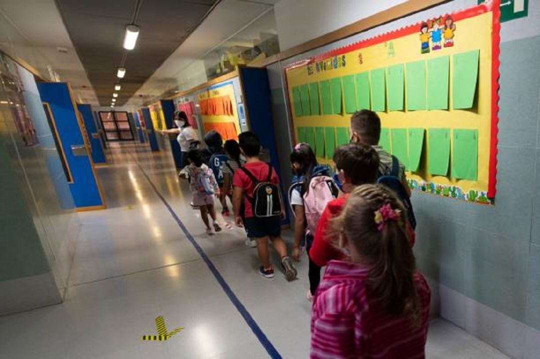 Grupo de niños se dirige en cola a clase siguiendo las medidas de seguridad e higiene