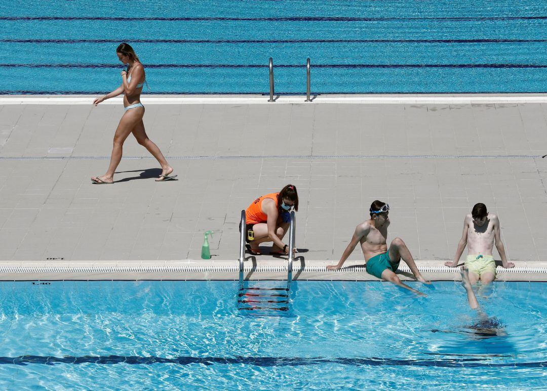 Bañistas disfrutan del verano dentro de una piscina.