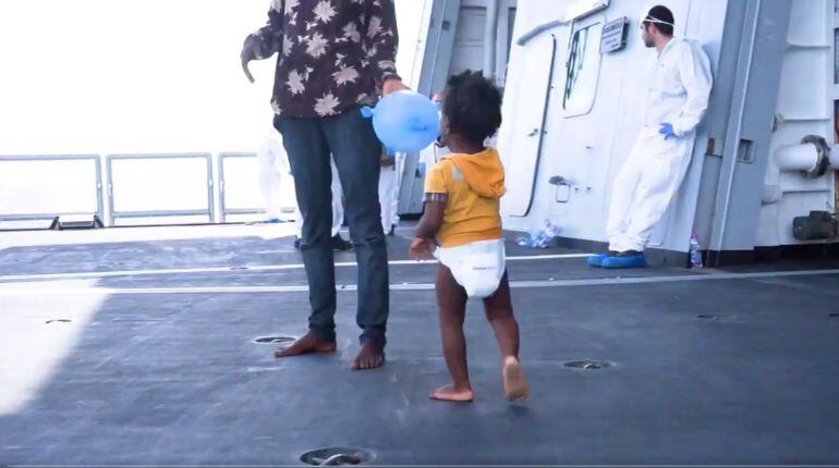 Una niña migrante camina por la cubierta de un barco tras ser rescatada del mar