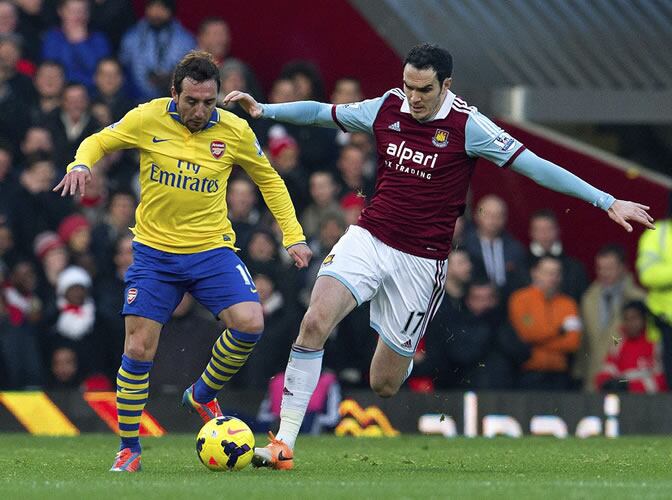 Santi Cazorla lucha por el control del balón ante el defensa del West Ham United Joey O&#039;Brien