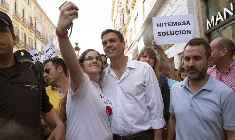 El secretario general del PSOE, Pedro Sánchez, se fotografía con una mujer durante el paseo que ha realizado por el centro histórico de Málaga.