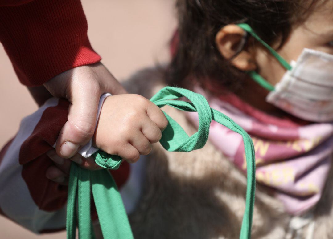 Una niña pasea de la mano de un adulto durante el estado de alarma