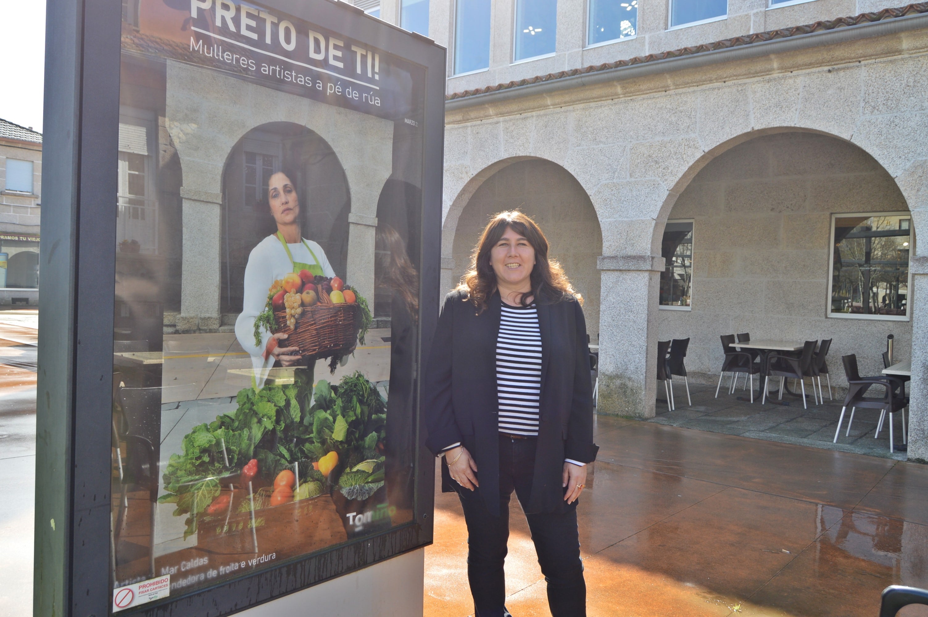 Conchi Garrido, comisaria de la muestra &quot;Preto de ti!. Mulleres artistas a pé de rúa&quot;, junto a uno de los paneles donde se expone.