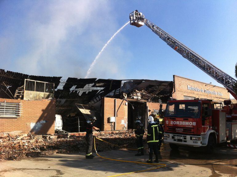 Bomberos trabajando en las naves calcinadas por el incendio en Villalobón