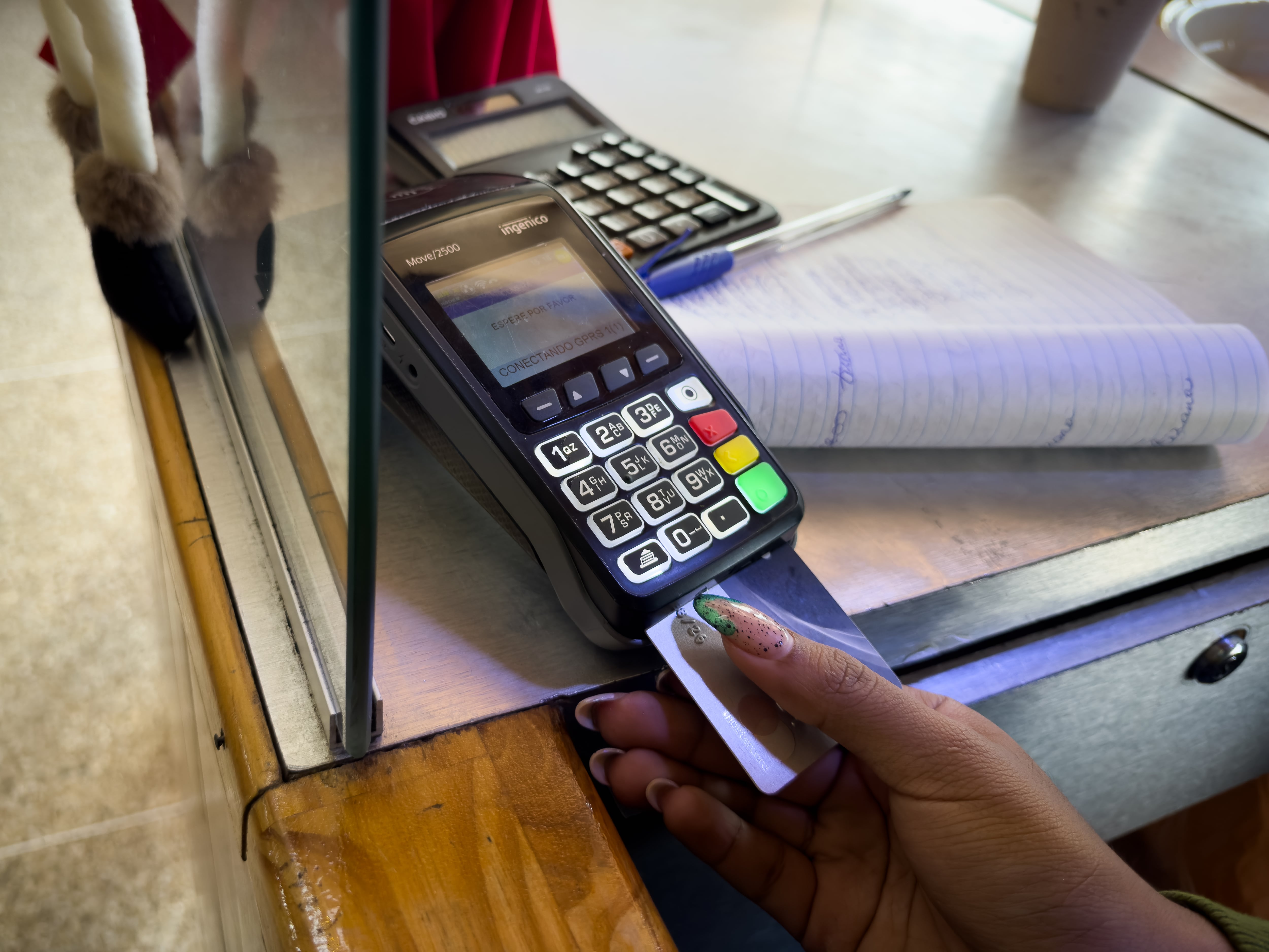 Una mujer hace un cobro con una tarjeta de débito en su negocio. EFE/ Rayner Peña R.