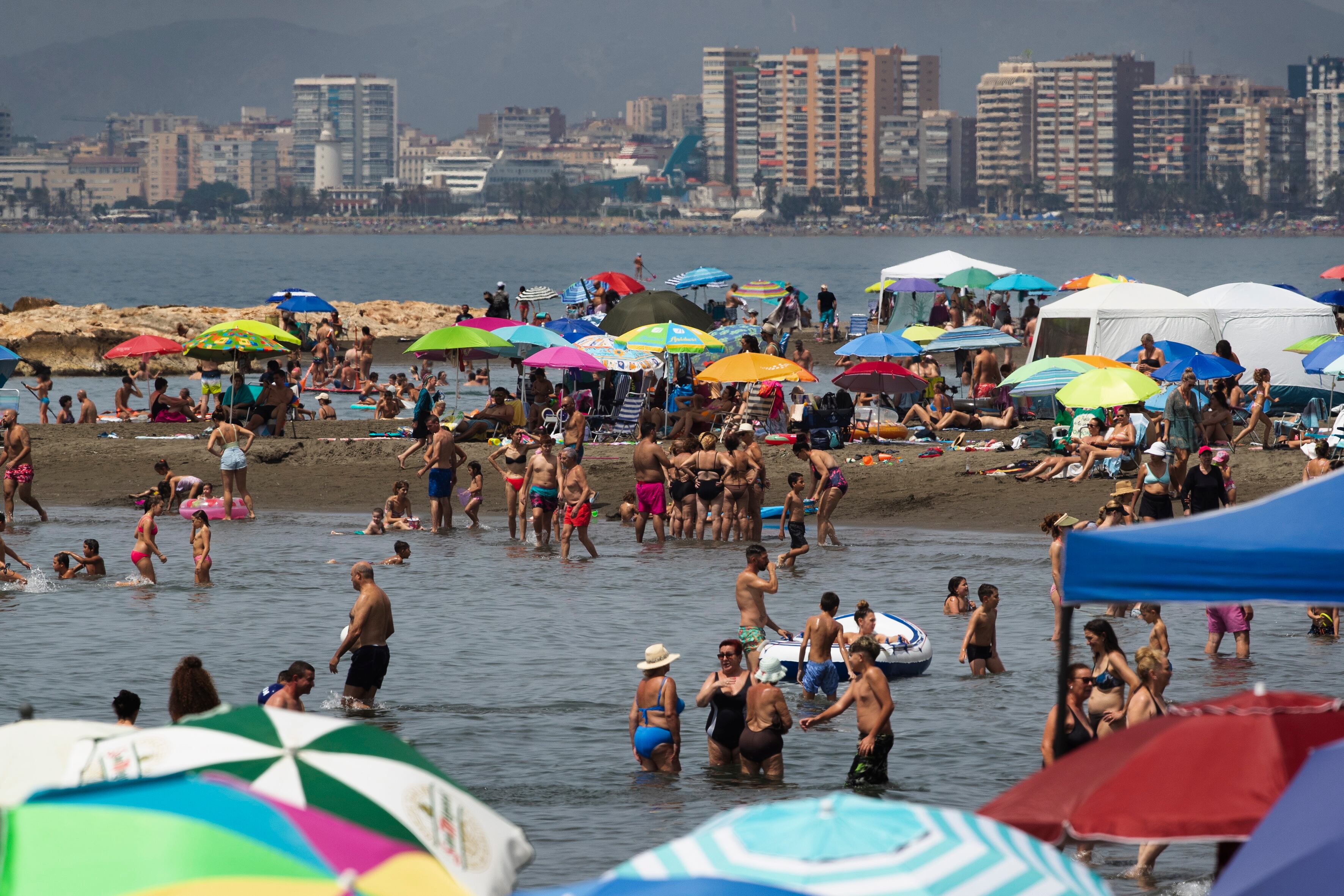 GRAFAND4092. MÁLAGA, 23/07/2023.- Numerosas personas llenan la playa del Palo de Málaga hoy domingo 23J en una jornada de elecciones generales en la que se compagina las urnas y la playa y donde la participación en Andalucía se sitúa a las 14:00 horas en un 42,05 por ciento, 6,25 puntos por encima de la registrada en los comicios de noviembre de 2019, en los que se situó en el 35,81 por ciento a la misma hora. EFE/Jorge Zapata
