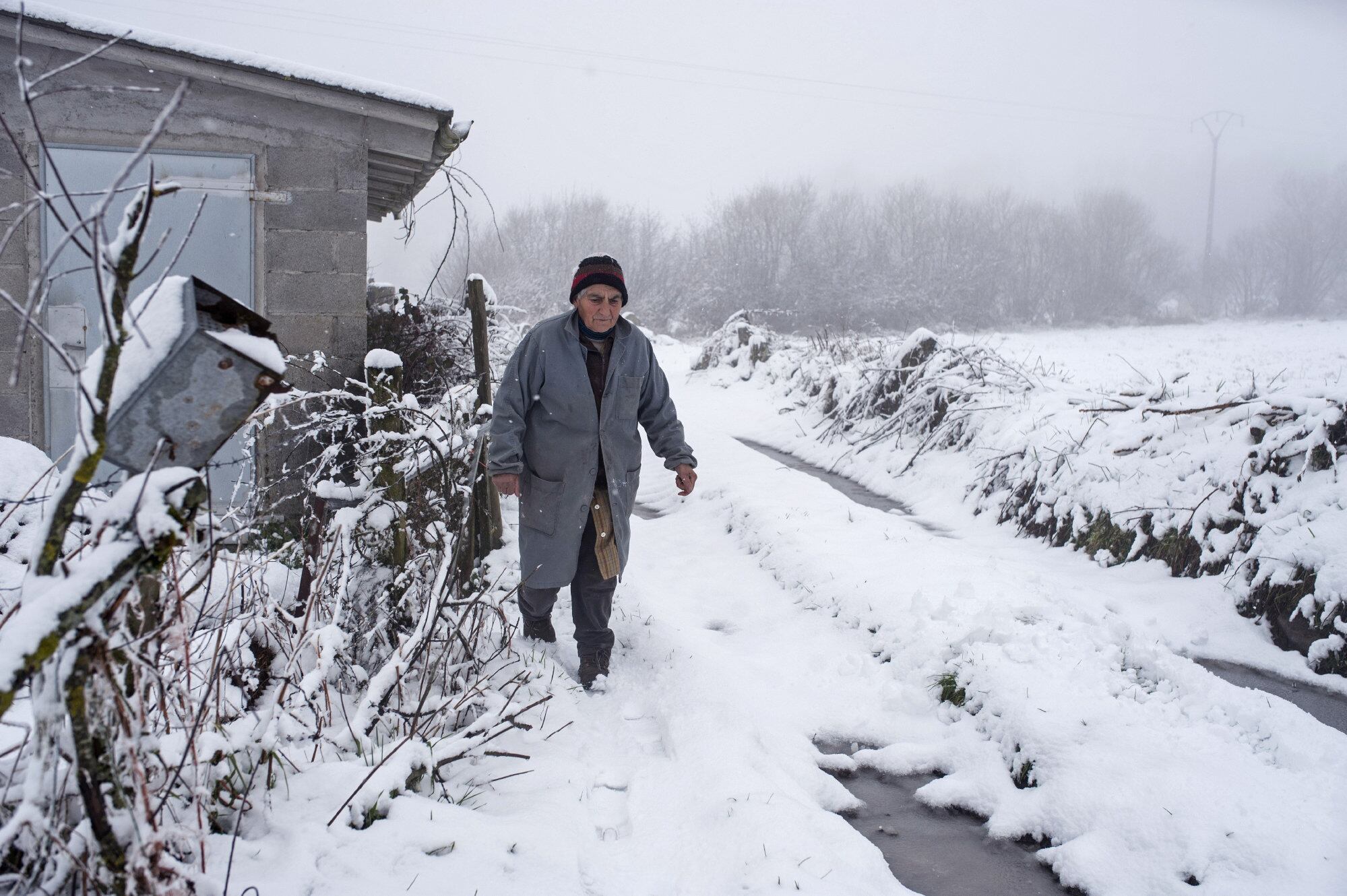 Foto de archivo. Una mujer camina hoy por la superficie nevada en el pueblo de Casetas do Rodicio, Maceda (Ourense). EFE/BRAIS LORENZO