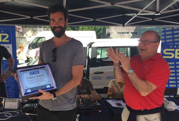 Asier Zubiria recibe su placa homenaje aplaudido por nuestro 'profe' Xabi Gezala, encargado de entregar todos los años este galardón