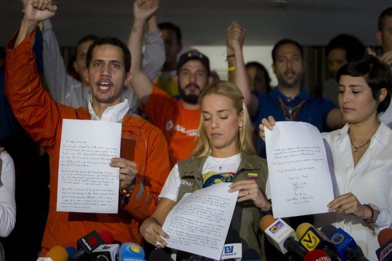 Lilian Tintori (c), junto a Patricia Gutiérrez (d), esposa de Daniel Ceballos, enseña una carta escrita por su esposo Leopoldo López durante unas declaraciones a la prensa en la ciudad de Caracas (Venezuela)