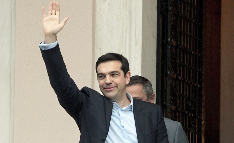 El líder de la izquierdista Syriza, Alexis Tsipras, saluda al público congregado al llegar a la oficinas del Primer Ministro