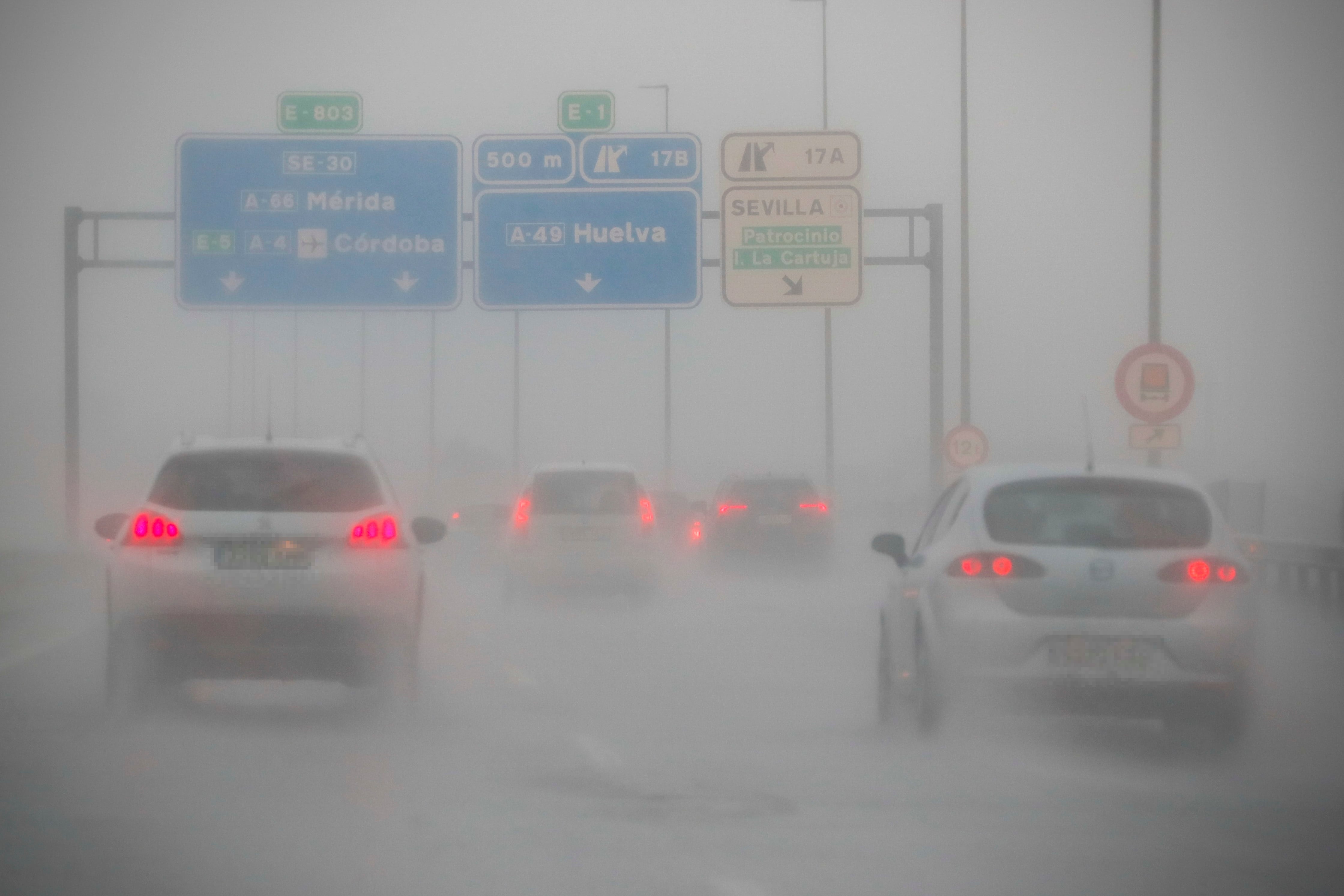 Varios vehículos circulan bajo la lluvia este jueves